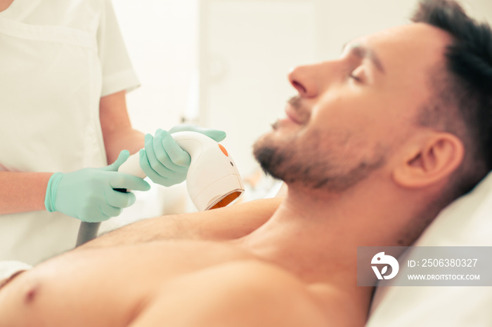 Selective focus of the laser hair removal tool in the hand of medical worker