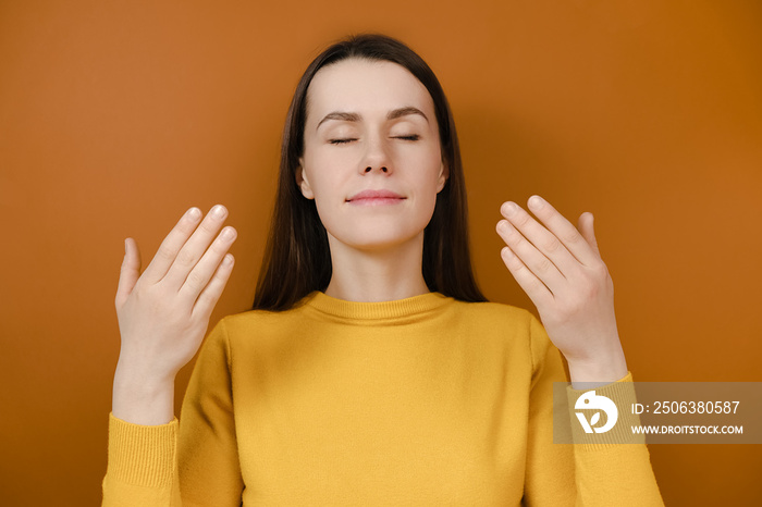 Relaxed brunette woman enjoying good smell or pleasant fragrance, serene mindful young female taking