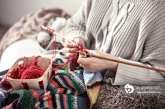 woman knits knitting needles on the couch