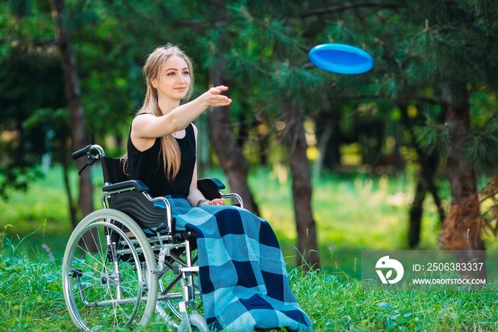 A young disabled girl plays Frisbee with her younger sister. Interaction of a healthy person with a 