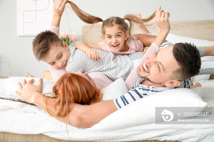 Happy family having fun on bed at home