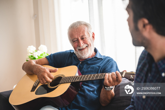 Eldery Father and adult son are playing music and sing a song together. The happy family concept wit