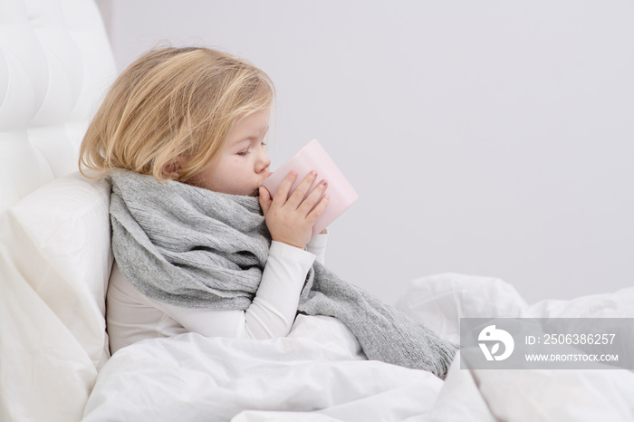 little sick girl drinking from a mug