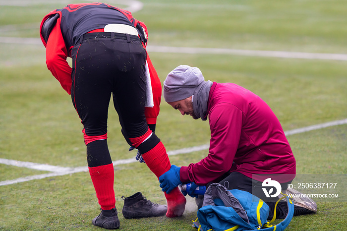 运动医生在治疗受伤运动员时使用冷冻喷雾