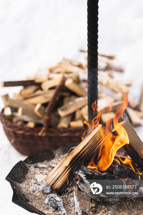 Firewood burning inside the fire-pit during cold winter day