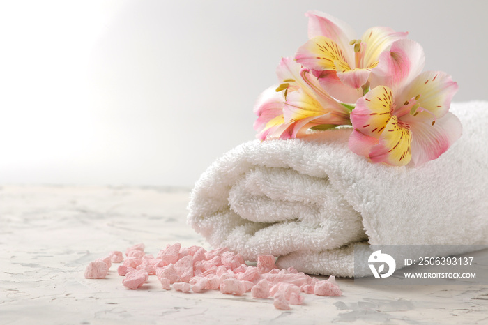 浴巾、海盐和鲜花的水疗组合。水疗概念。在浅色背景上。