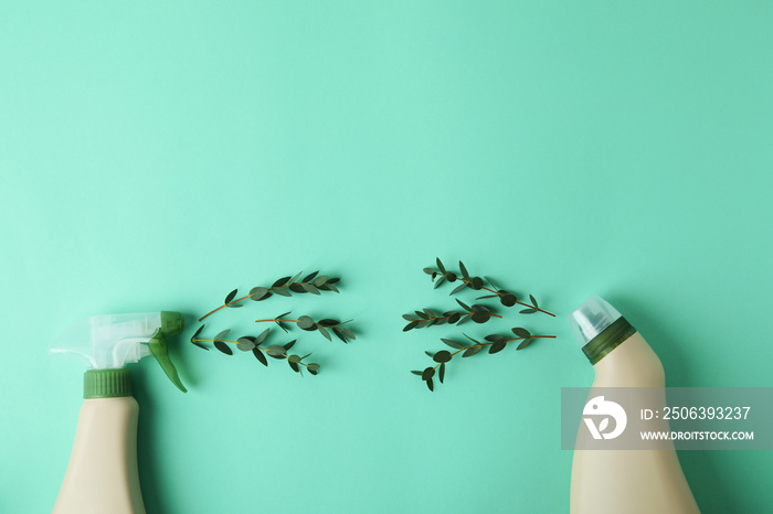 Blank detergent bottles and twigs on mint background