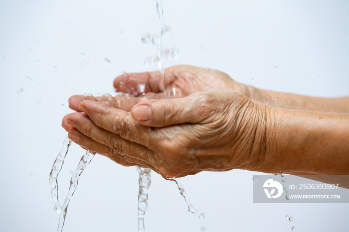 Senior woman washing her hands in white background, Close up & Macro shot, Selective focus, Preventi