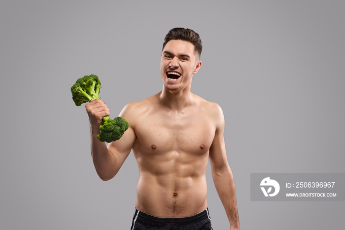 Strong man lifting broccoli dumbbell