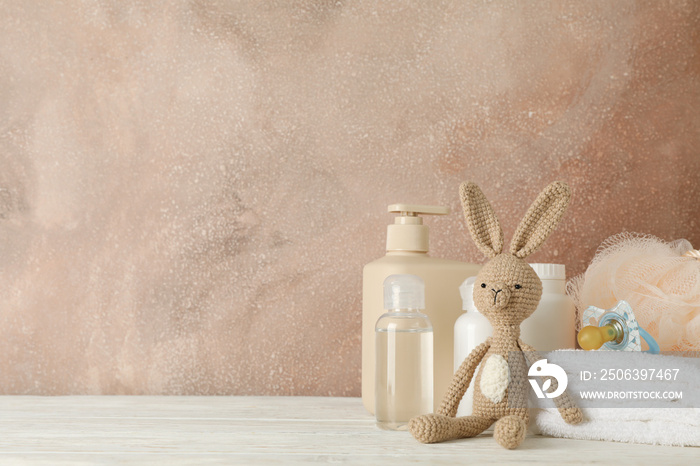 Baby hygiene accessories on wooden table against brown background