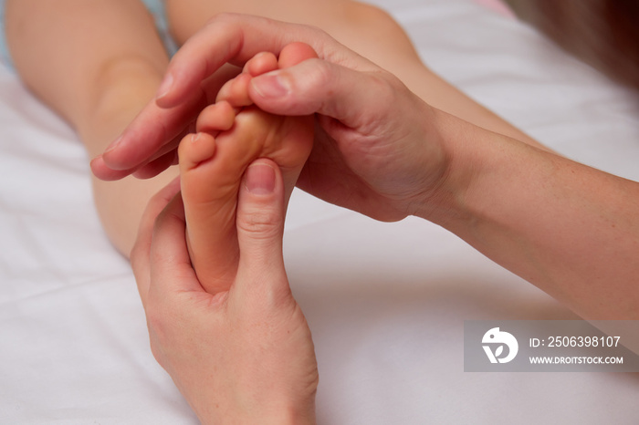 Doctor performing pediatric foot massage to prevent development of flat feet