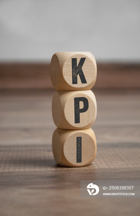 Cubes and dice with KPI Key Performance Indicator on wooden background