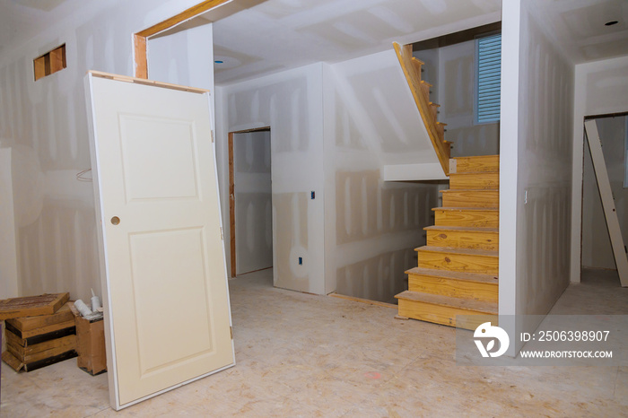 Finishing putty in the room walls plasterboards with room under construction