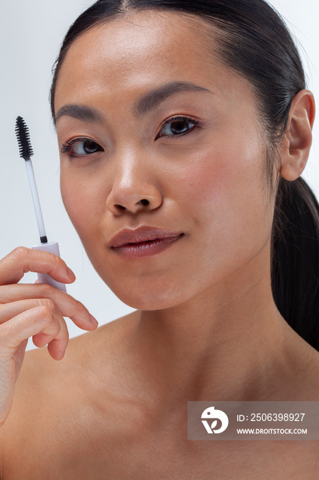 Close-up of woman holding mascara applicator