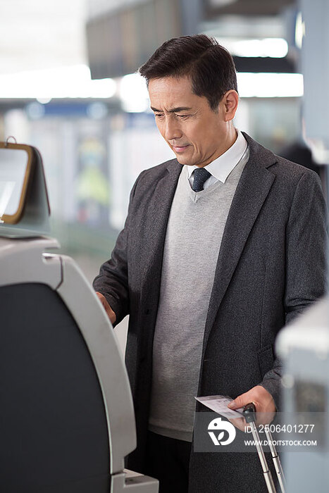 商务男士在机场使用自动售票机