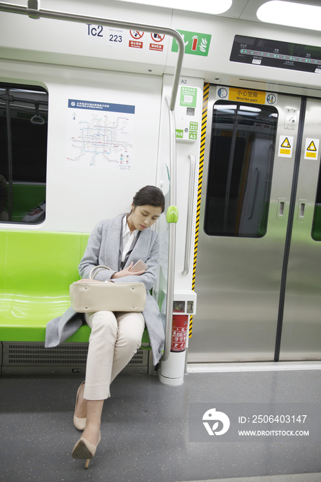 疲倦的青年女人在地铁上休息