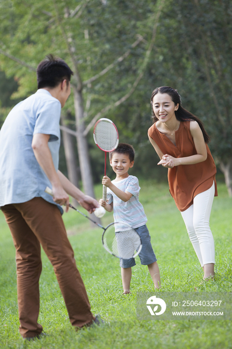 年轻的父母教儿子打羽毛球