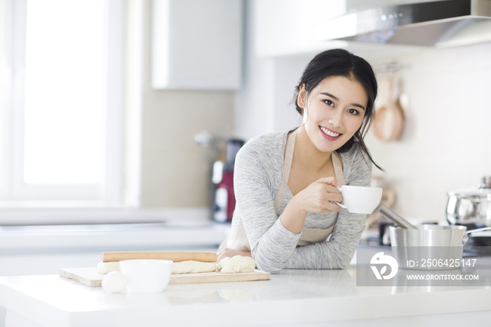 年轻女子在厨房喝咖啡