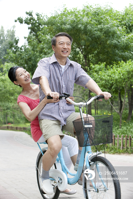 老年夫妻公园内骑自行车