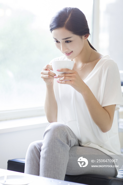 快乐的年轻女子在咖啡店喝咖啡