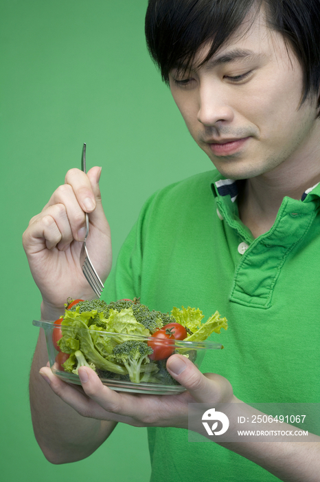 年轻男子吃蔬菜沙拉