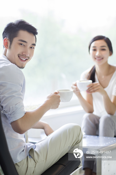 快乐的年轻情侣在咖啡店喝咖啡