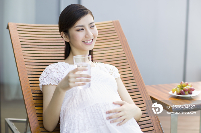 孕妇靠在躺椅上喝水