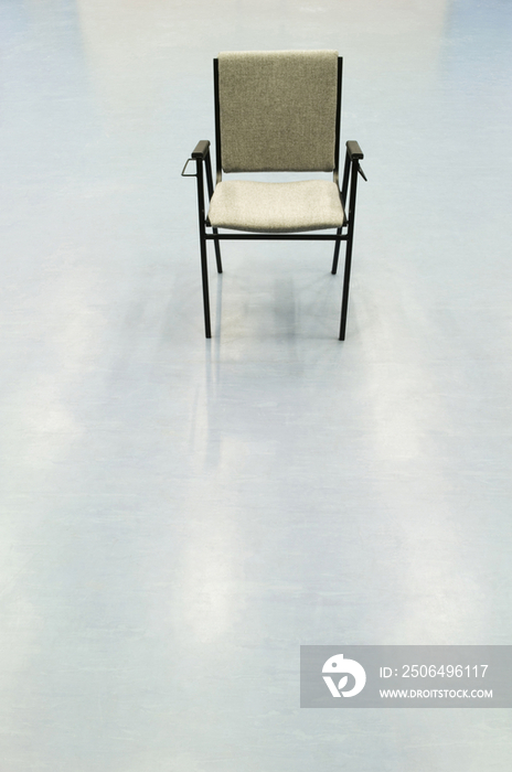 Single chair in the otherwise empty main hall of a modern secondary school