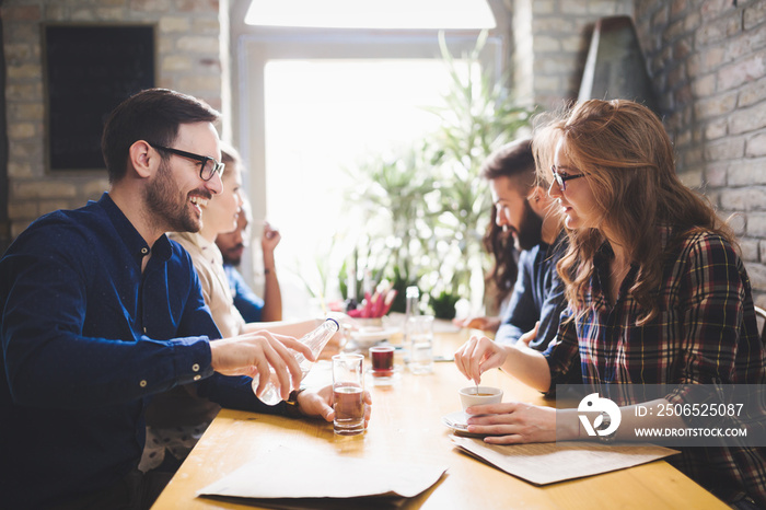 Colleagues from work socializing in restaurant and eating together