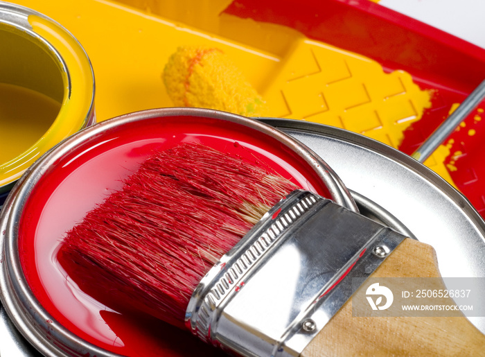 红色和黄色油漆罐和刷子和滚筒