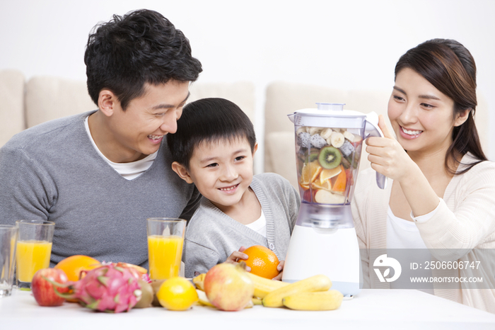 开心的一家人使用榨汁机做果汁