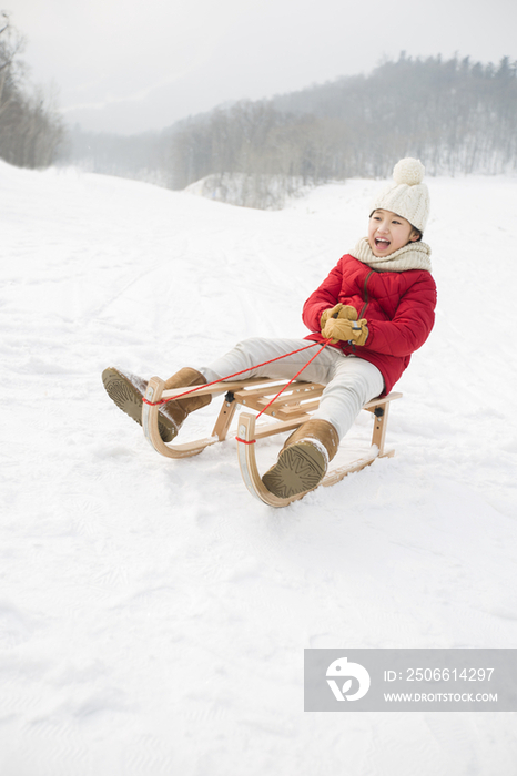 快乐的小女孩乘雪橇滑雪