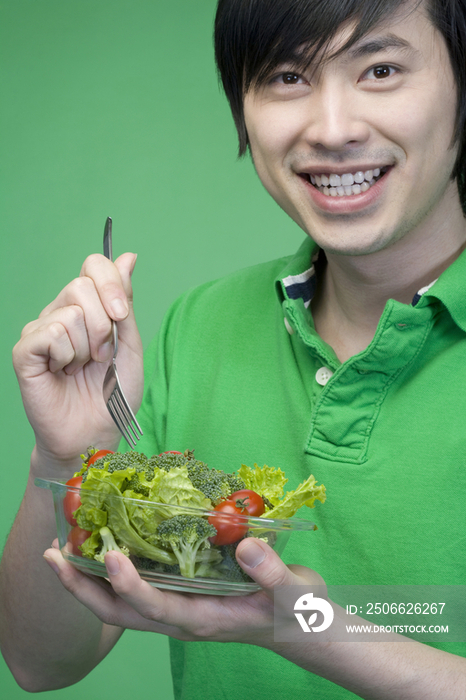 年轻男子吃蔬菜沙拉