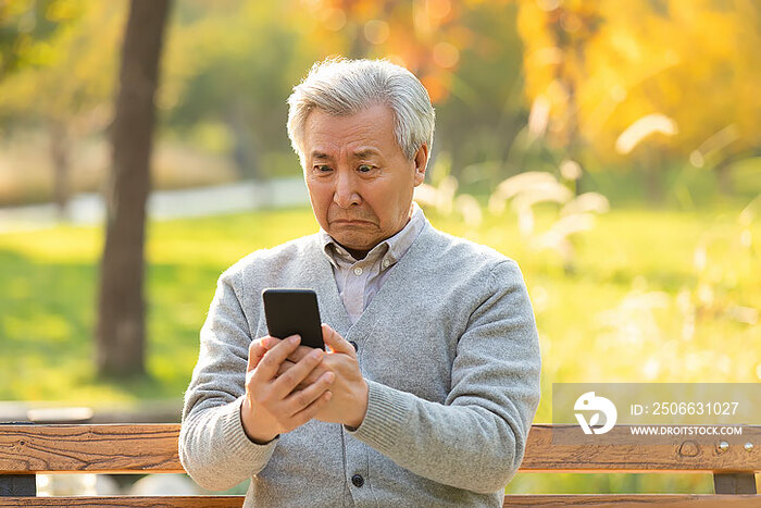 老年男子在公园使用手机