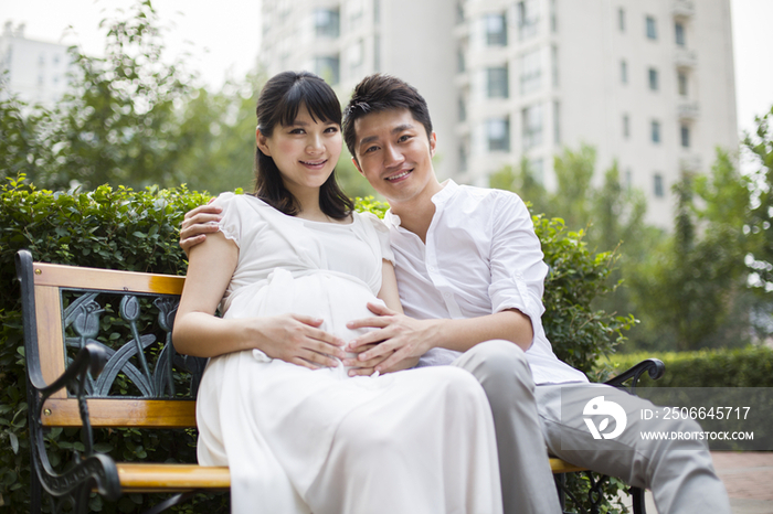 孕妇和丈夫坐在长椅上