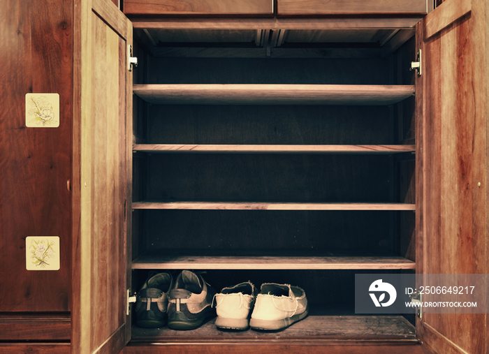 Two pairs of shoes in an old wooden cabinet