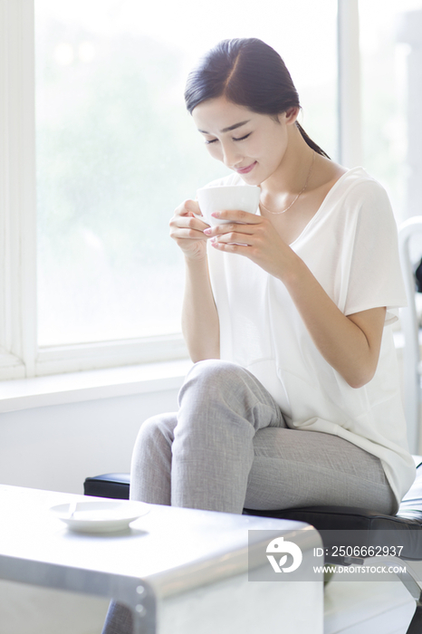 快乐的年轻女子在咖啡店喝咖啡