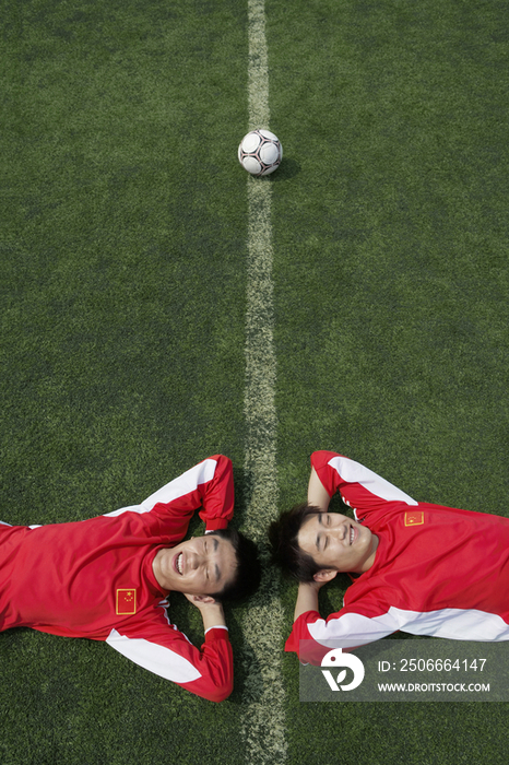 足球运动员躺在草地上
