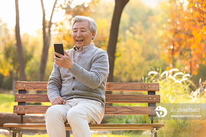 老年男子在公园使用手机