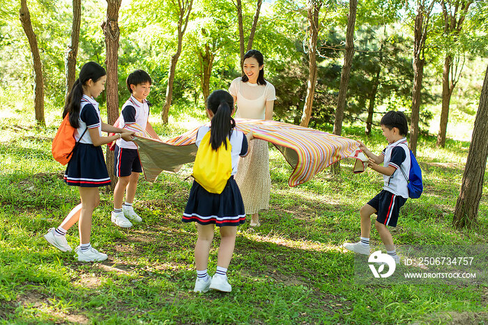 快乐的小学生和老师铺野餐垫