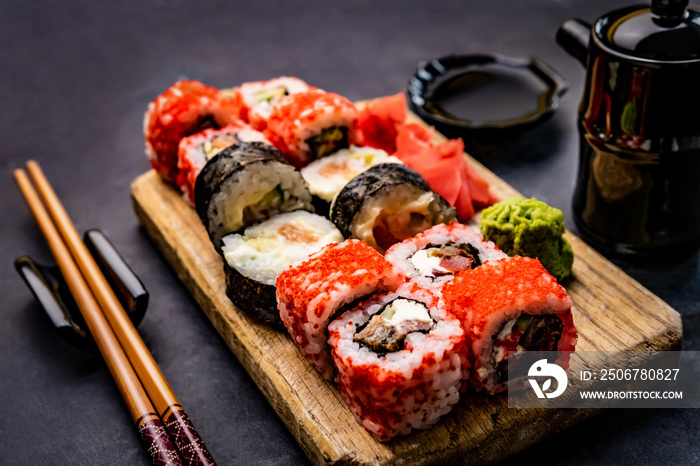 传统寿司寿司套餐的特写，用筷子、酱油和gre放在木板上