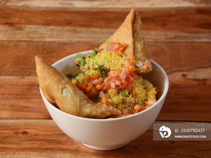 Samosa chaat, Indian special traditional street food served over a rustic wooden background, selecti