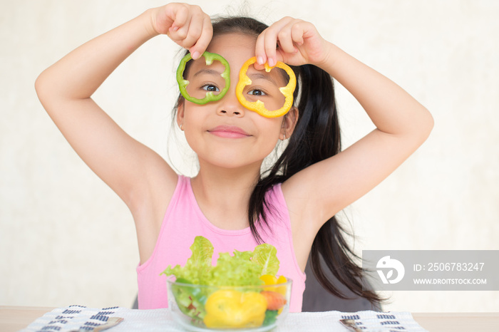 little asian girl enjoy eating with vegetable salad with bowl in breakfast time at home. eating vege