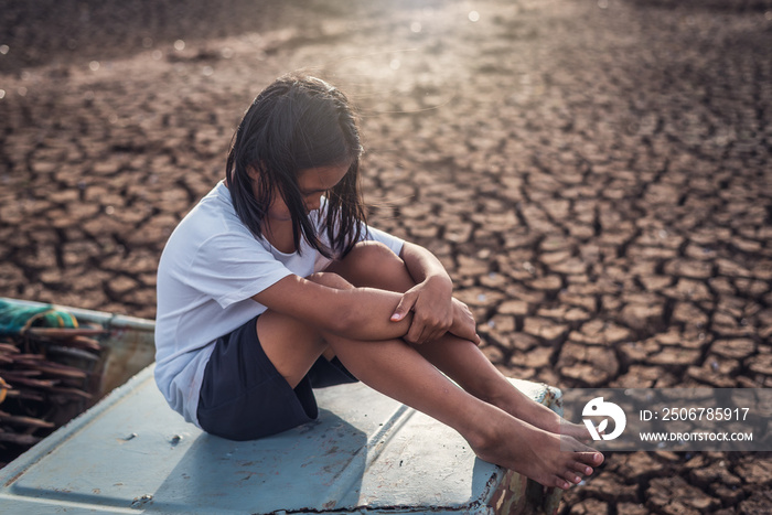 悲伤的亚洲女孩坐在船上遭受干旱，气候变化导致全球变暖。