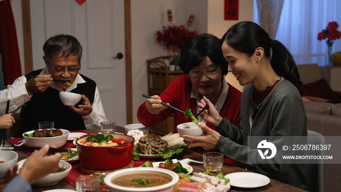 幸福的亚洲奶奶和媳妇在一起吃饭时互相给食物