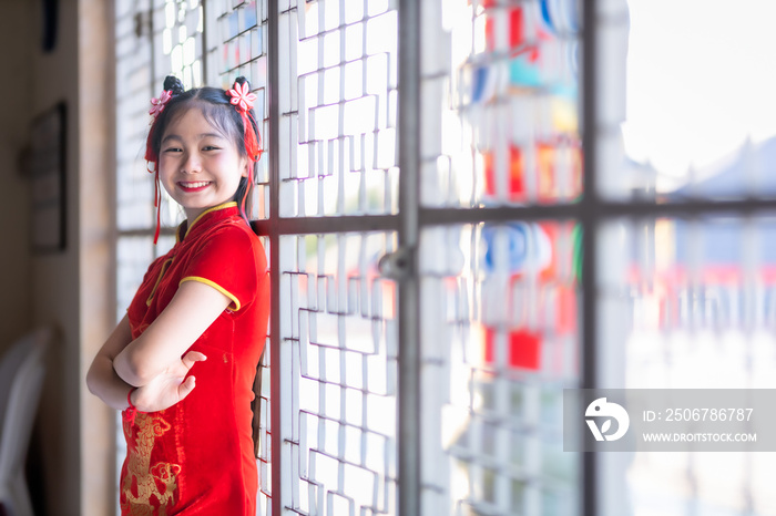 little Cute Asian girl wearing traditional Chinese cheongsam red with paper lanterns with the Chines