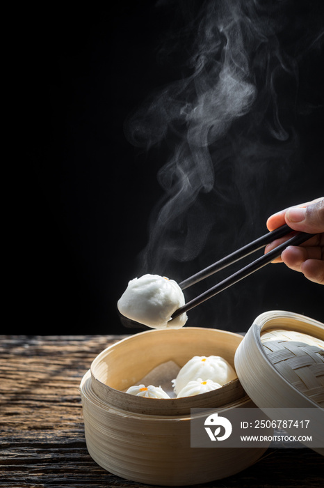 盘子里的中国馒头和竹篮。热食概念。头顶上的男人吃chi的镜头