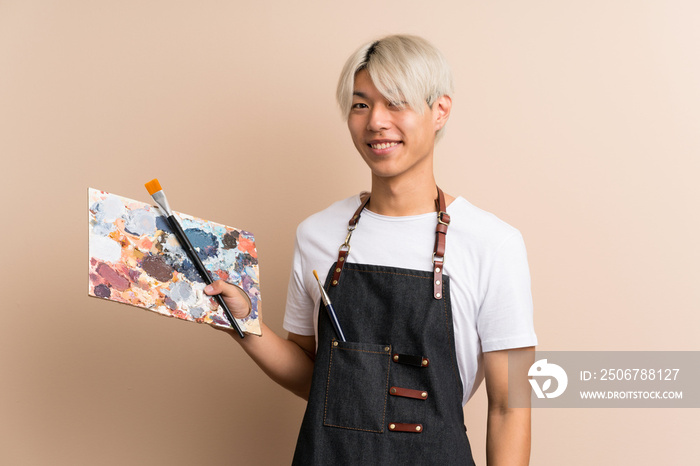 Young asian man over isolated background holding a palette