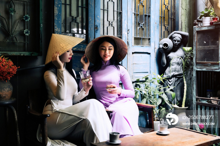 Vietnam woman wearing Ao Dai culture traditional drinking coffee at Ho Chi Minh in Vietnam,vintage s