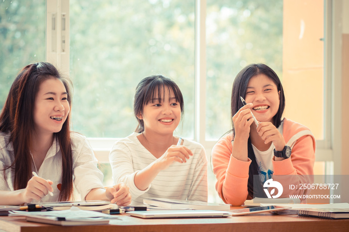 Happy Asian young woman doing group study. Asian University or college students studying together wi